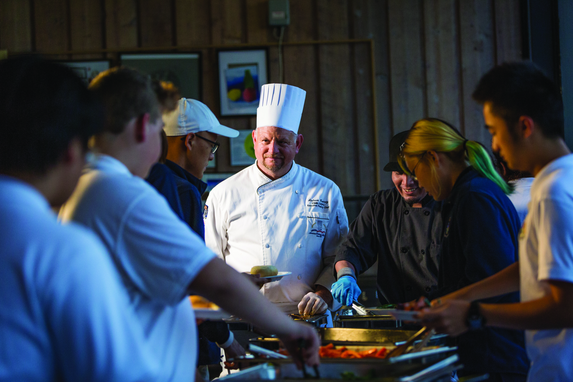 A Storm King chef serves students at the family-style dinner line