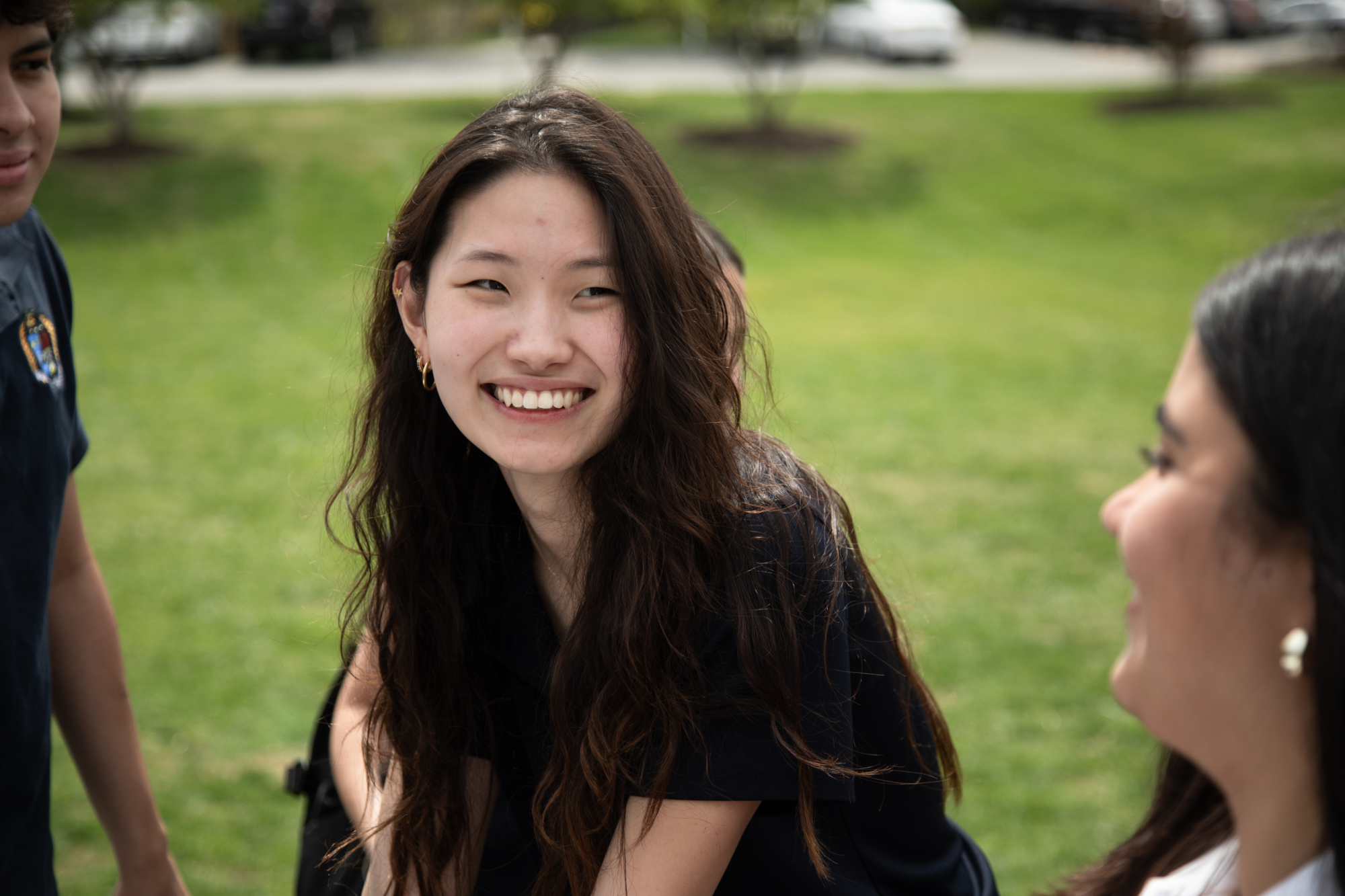 A student laughs with friends on the campus lawn