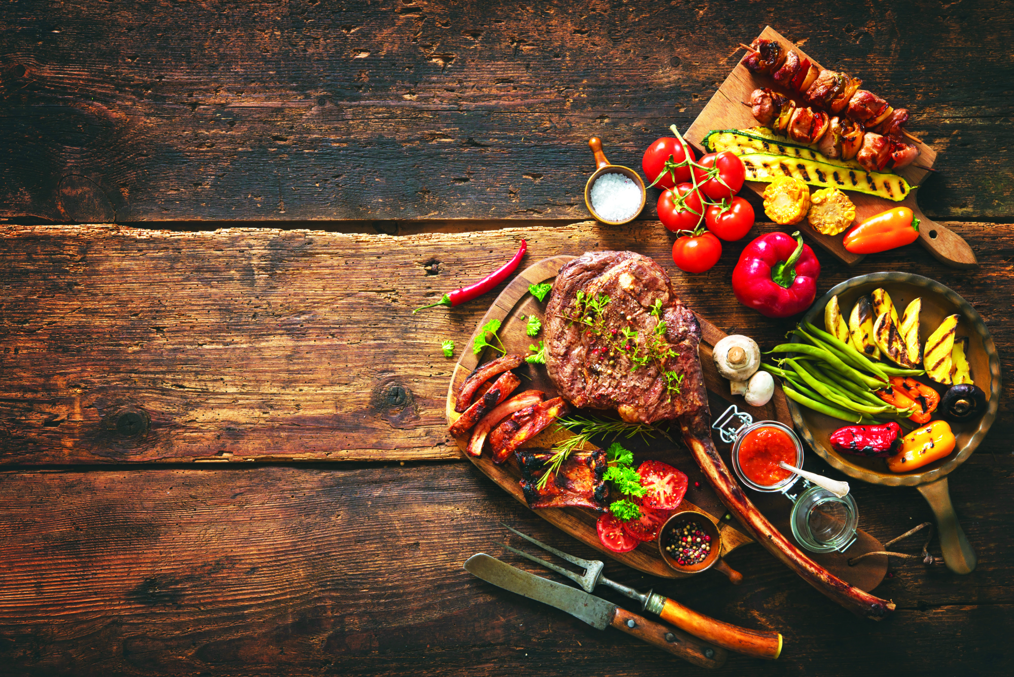 A grilled entrée with roasted vegetables and skewers