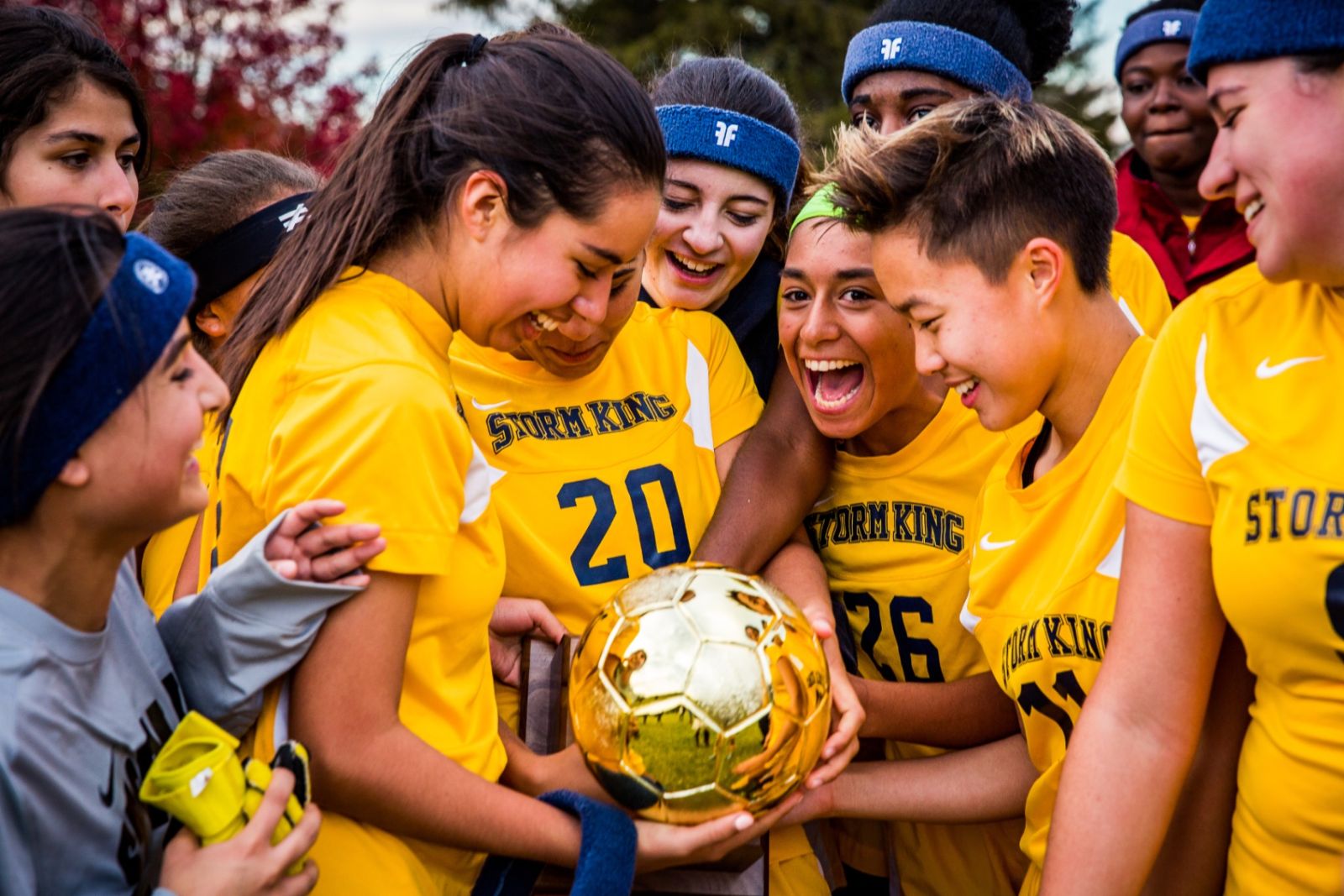 Storm King girls soccer team celebrating with a championship trophy