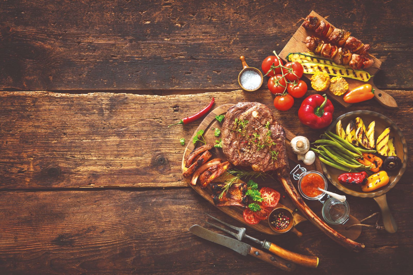 A grilled entrée with roasted vegetables and skewers