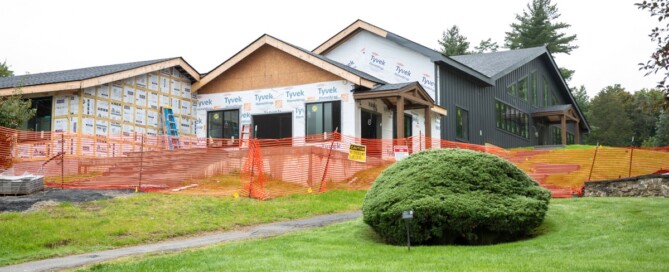 Exterior of the Fischer Academic Center under construction, with new roof lines, windows, and a covered entry