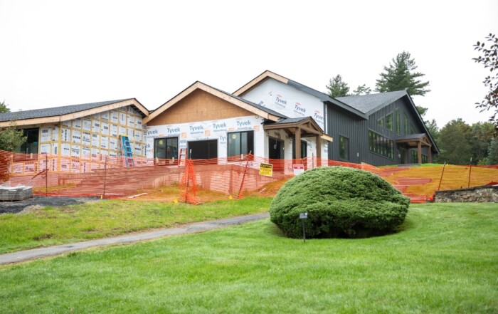 Exterior of the Fischer Academic Center under construction, with new roof lines, windows, and a covered entry