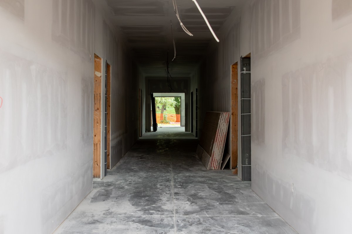 Drywalled central hallway inside the Fischer Academic Center, with classroom doorways on either side