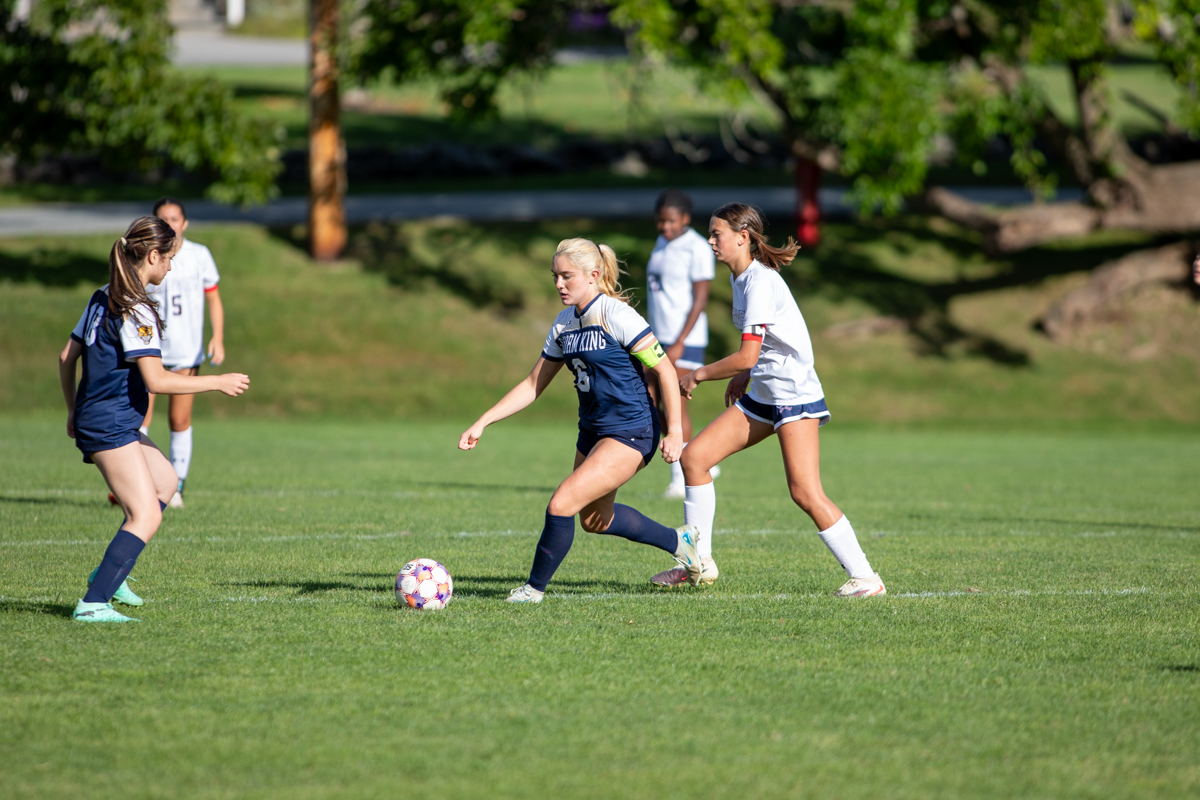 Storm King girls soccer captain dribbles the ball upfield against a defender