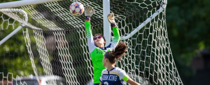 Storm King girls varsity soccer goalkeeper leaps to make a save at the crossbar