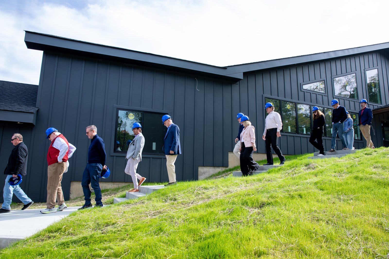 Trustees walk along the exterior of the Fischer Academic Center during a hard-hat construction tour