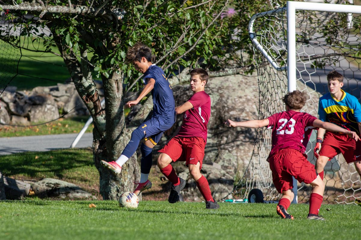 Storm King Cougars boys varsity soccer player controls the ball in front of the NYMA goal as defenders close in